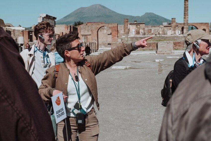 A group of people at an archaeological site with ruins and a mountain in the background. 1