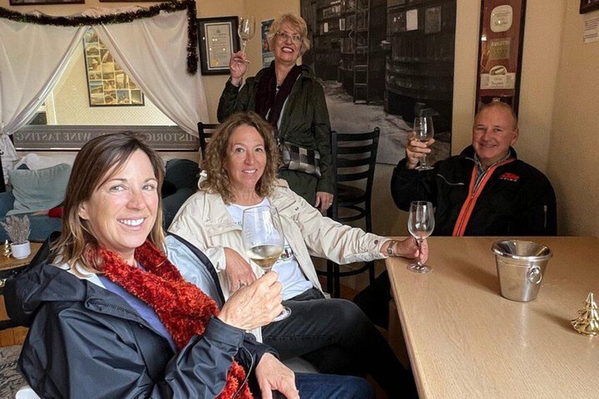 A group of people sitting at a table, holding wine glasses. 3