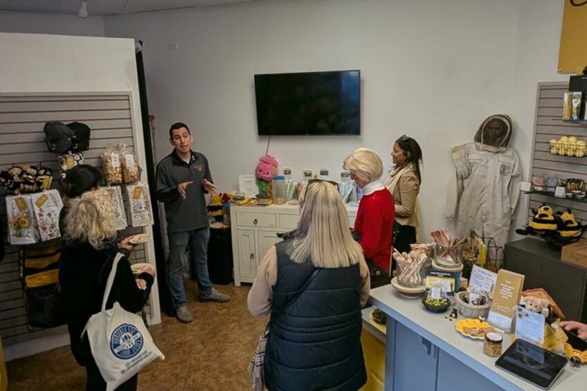 A group of people in a store with various items on display, including a television on the wall and a mannequin. 3