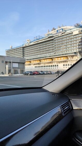 A cruise ship docked at a port with a building labeled "CRUISES" in the background. 5
