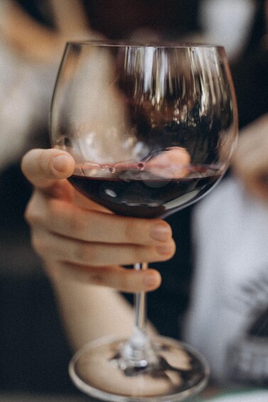 Una mano sosteniendo una copa de vino. 3