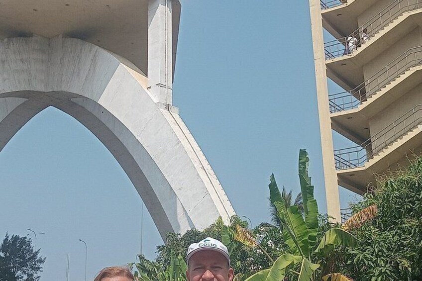 Un puente de concreto, un edificio de varios pisos y abundante vegetación. 2