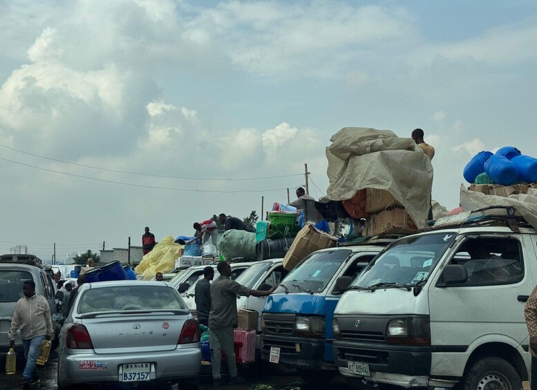 A crowded parking lot with several cars and people. 5