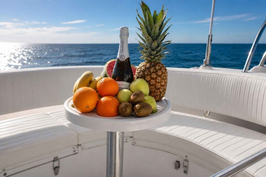 A table with fruits and a bottle on a boat. 5