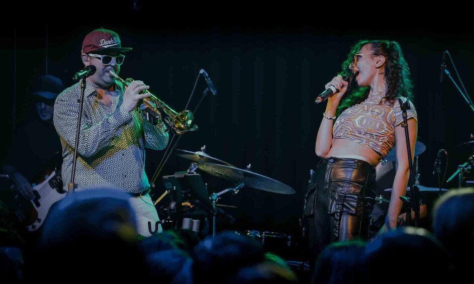 Two musicians performing on stage with musical instruments. 3