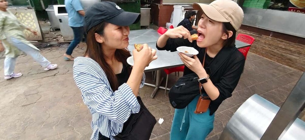 Two people eating at an outdoor cafe. 1