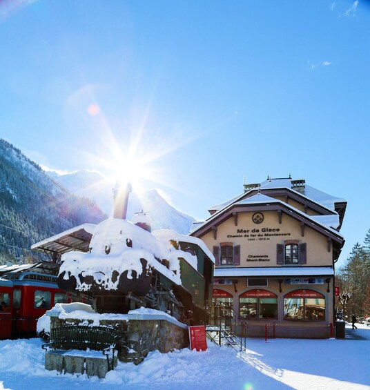 A snow-covered building with a sign reading "Mer de Glace" and "Chamonix Mont-Blanc" in the background. 1