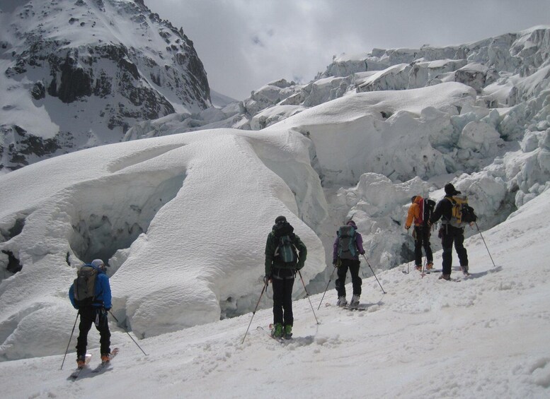 A group of skiers navigating a snowy mountain terrain with large snow formations. 5