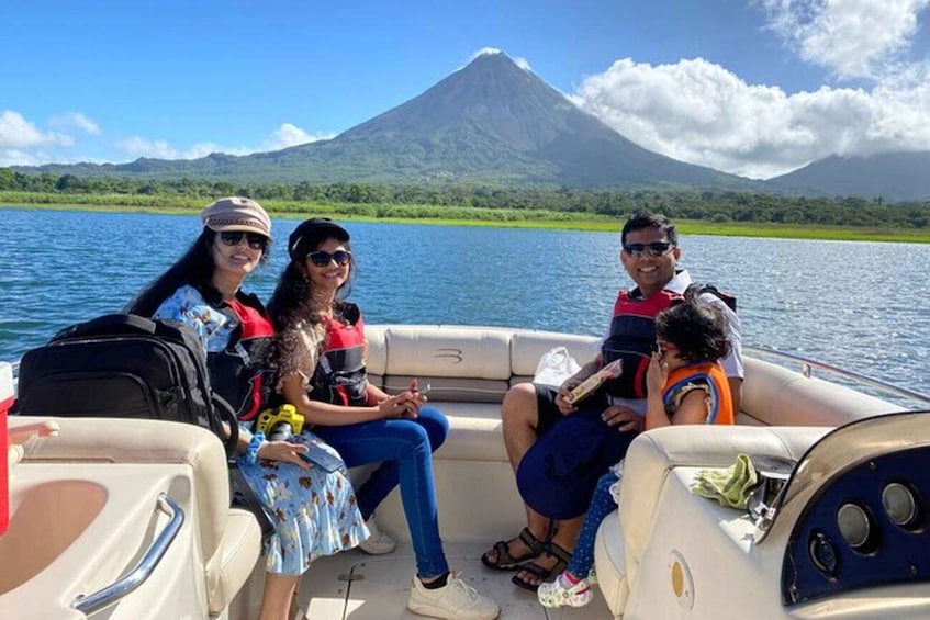 A group of people on a boat with a volcano in the background. 1