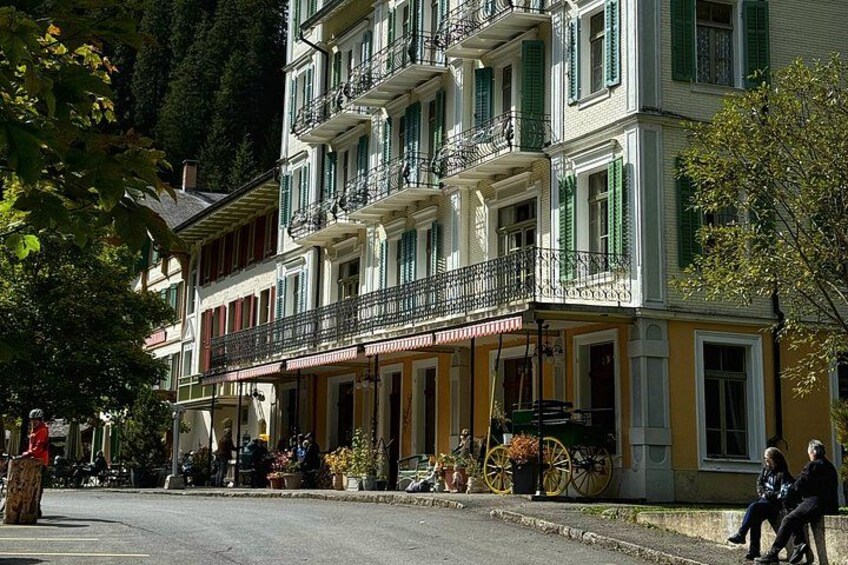 Un immeuble à plusieurs étages doté de balcons, une rue et une personne qui marche. 5