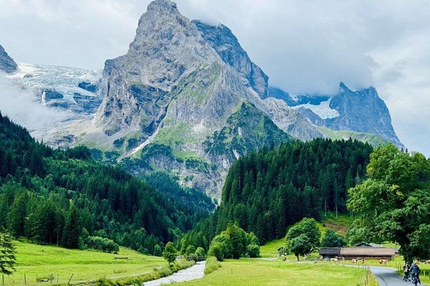 Un paysage montagneux caractérisé par un sommet imposant, une forêt dense et un petit bâtiment. 1
