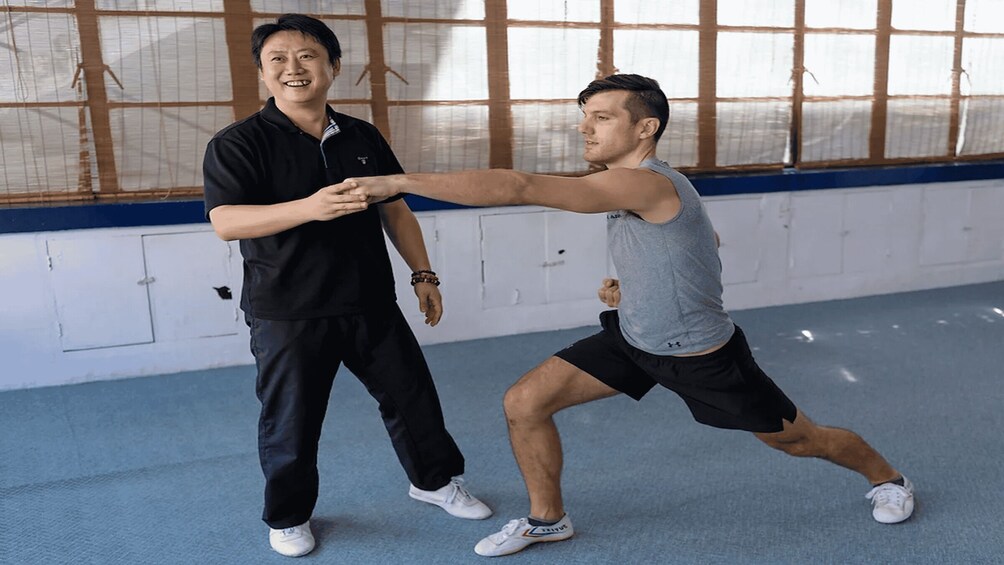 Two people practicing martial arts in a gym. 2