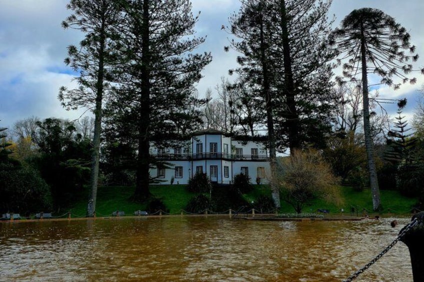 A house surrounded by tall trees and a body of water. 4