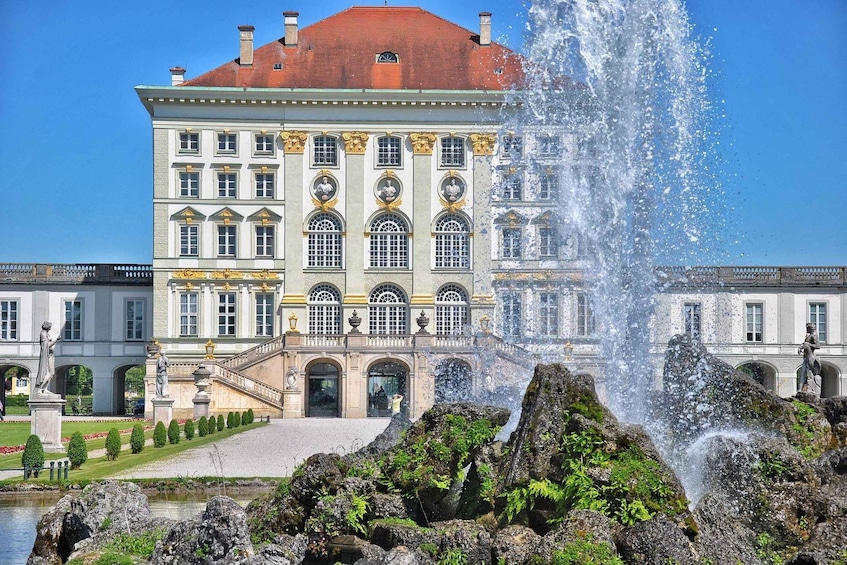 A grand building with a fountain in front. 1