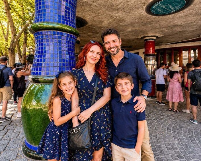 A family posing in front of a blue mosaic pillar. 2