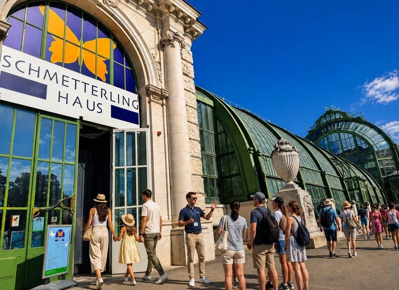 A building with a sign reading 'SCHMETTERLING HAUS' and a large glass structure to the right. 5