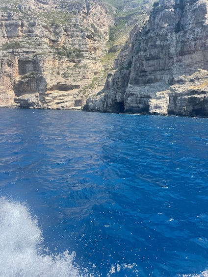 A coastal landscape with cliffs and a deep blue sea. 5