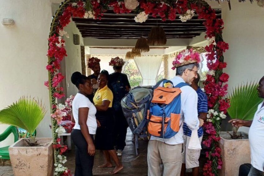 A group of people standing under a floral archway. 1