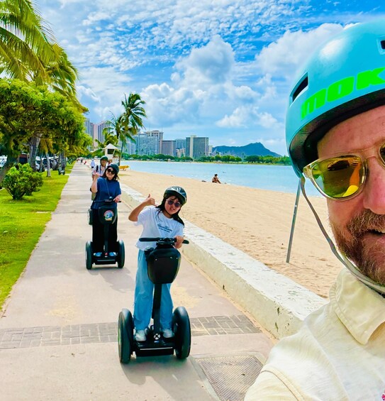 A person on a segway, another on a scooter, and a third person in the background. 4