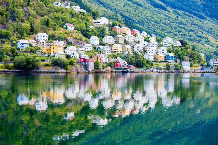 A hillside village with colorful houses reflecting on a calm lake. 4