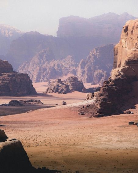 A desert landscape with rocky formations and a dirt road. 2