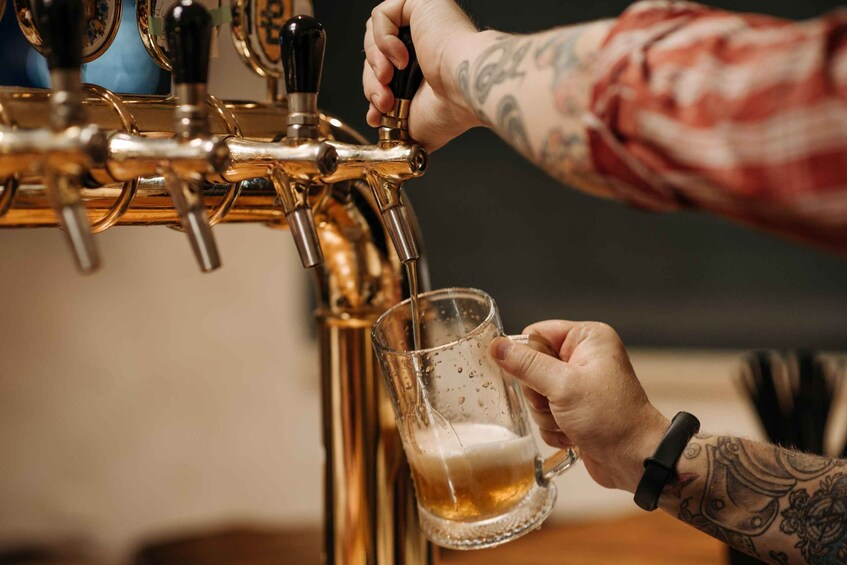 Una persona sirviendo cerveza de una llave a un vaso. 3