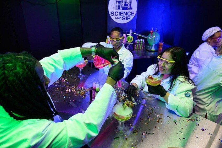 People in lab coats conducting experiments with colorful liquids and confetti. 2