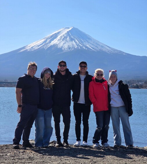 A group of people standing in front of a snow-capped mountain. 5