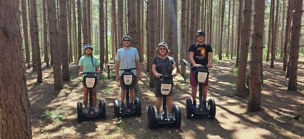 Four people on segways in a forest. 1