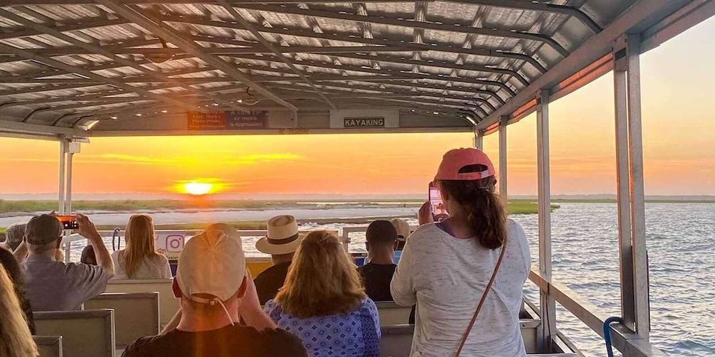 People on a boat watching a sunset over the water. 3