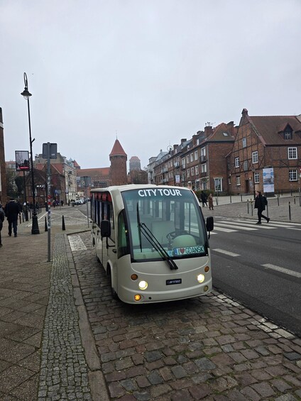 A city tour bus parked on a cobblestone street. 5