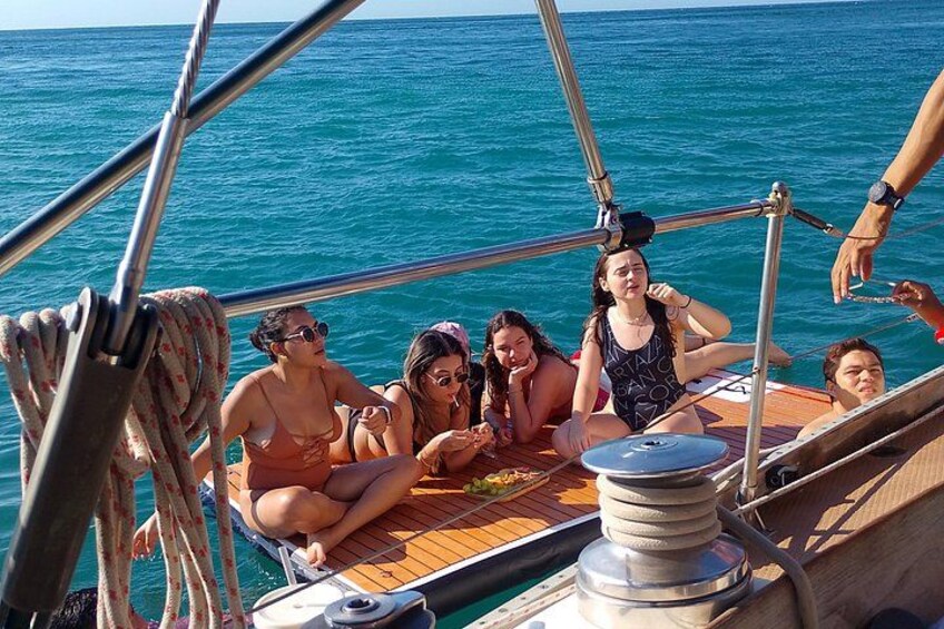 A group of people on a boat with a clear blue sea in the background. 3