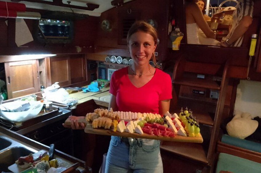 A person holding a tray with various food items in a kitchen. 2