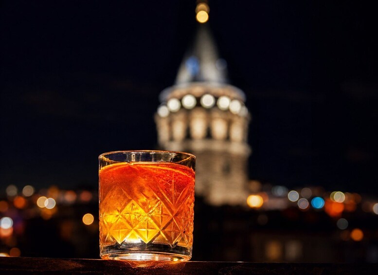 Un vaso con un diseño estampado, un paisaje urbano con una torre destacada al fondo, y luces borrosas que sugieren un ambiente nocturno. 4