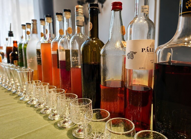 Una fila de botellas de vino y copas sobre una mesa. 2