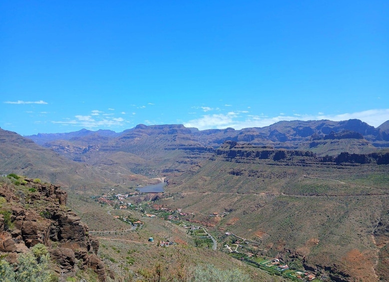 A mountainous landscape with a valley, scattered houses, and a lake. 1