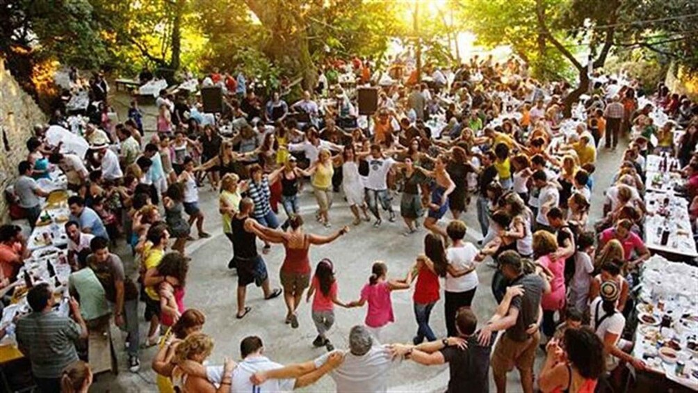 A crowded outdoor event with people dancing and socializing. 2
