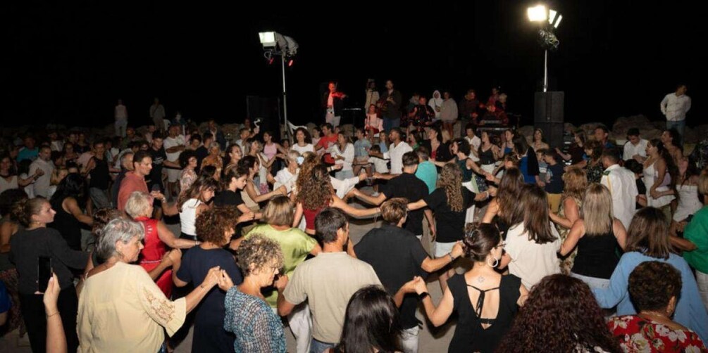 A large crowd dancing at an outdoor event. 5