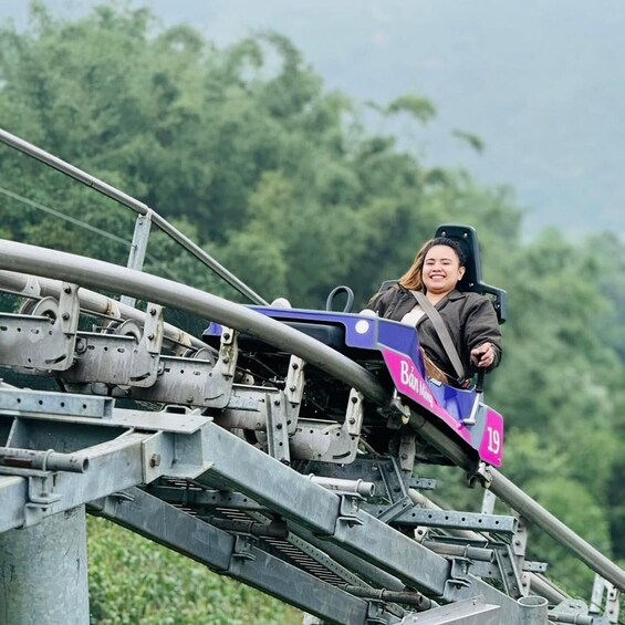 A person on a roller coaster track with a sign reading 'Bảo Minh' and the number '19'. 2
