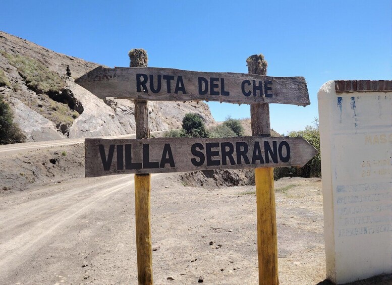 A signpost with 'RUTA DEL CHE' and 'VILLA SERRANO' pointing in different directions. 1
