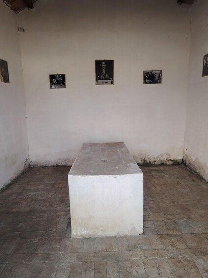 A room with a central rectangular table and three framed pictures on the walls. 3