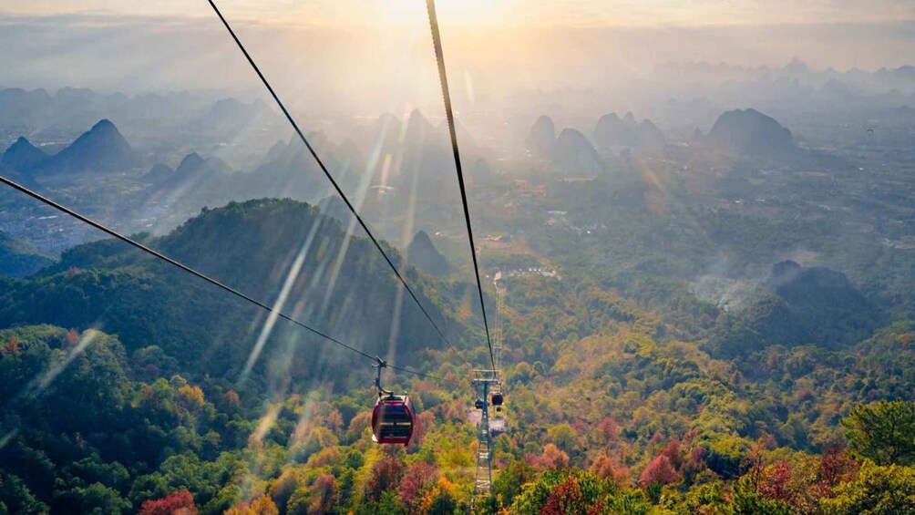 A cable car moving through a mountainous landscape with autumn foliage. 2