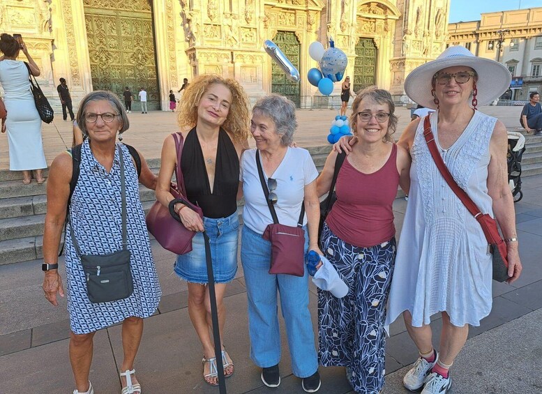 A group of people standing in front of a large, ornate building with intricate carvings. 3