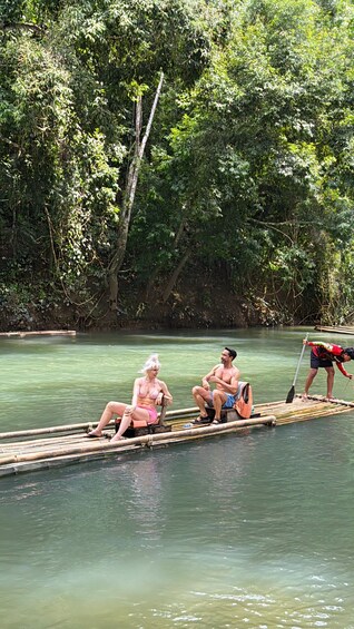 A river scene with a bamboo raft carrying three people. 2