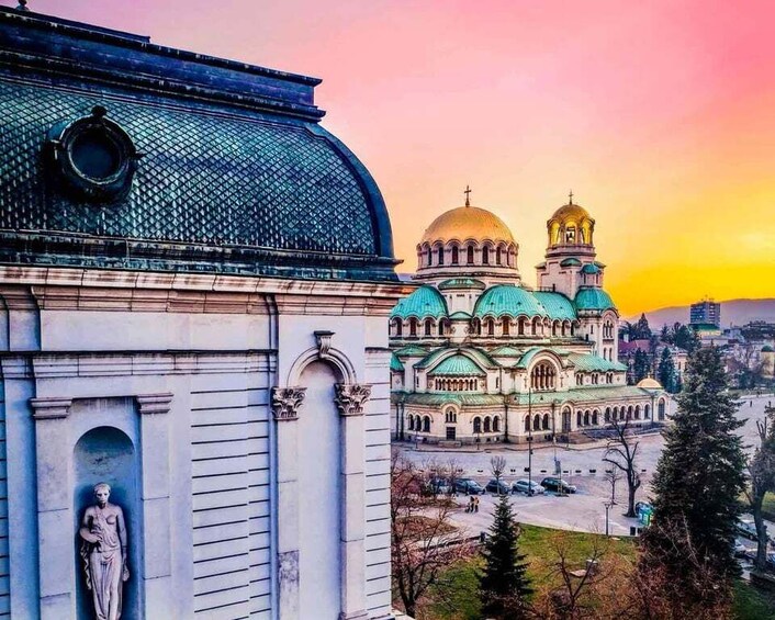 A historic building with a dome and a statue, and a church with multiple domes in the background. 2