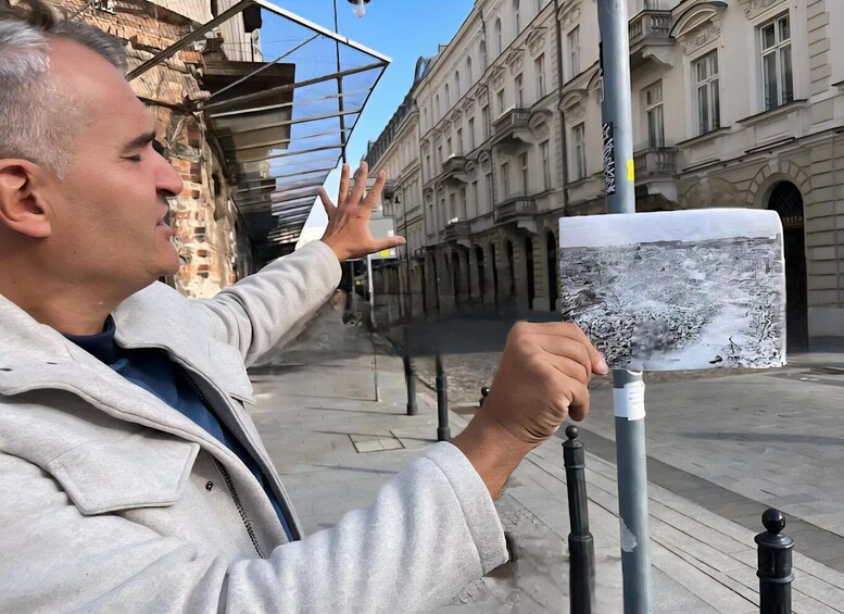 A person holding a large photograph of a cityscape. 1