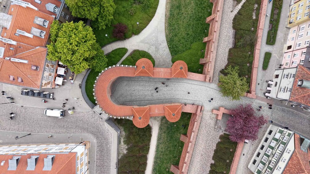 An aerial view of a roundabout with a central island, surrounding buildings, and greenery. 3