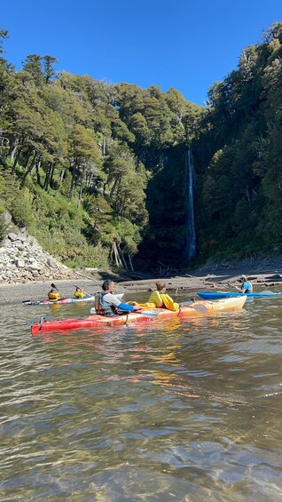 Kayakers on a river with a waterfall in the background. 5