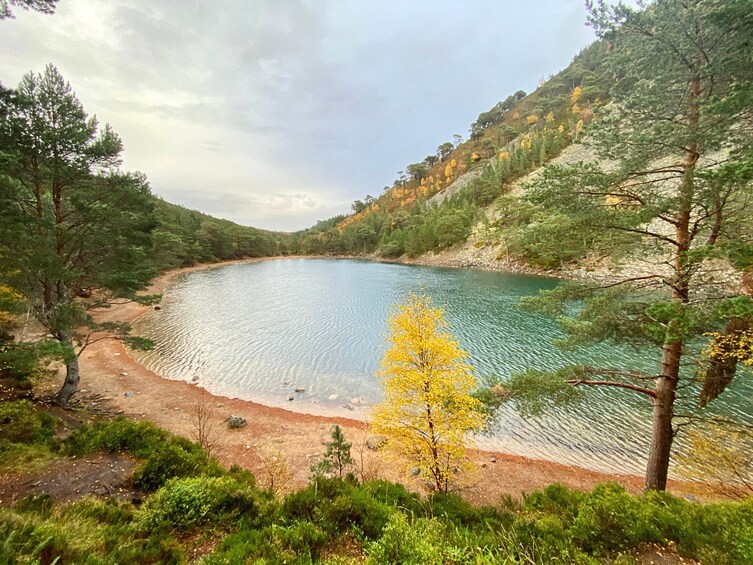 Un lac paisible, entouré d’une forêt dense et de collines rocheuses. 3