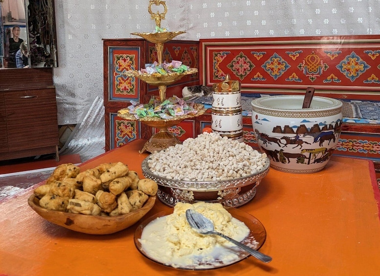 A traditional feast with various dishes, including a bowl of cookies, a plate of rice, and a decorative plate with a spoon. 4